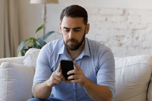 A serious man looking at his phone. 