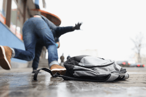 Man slipping and falling on a sidewalk.