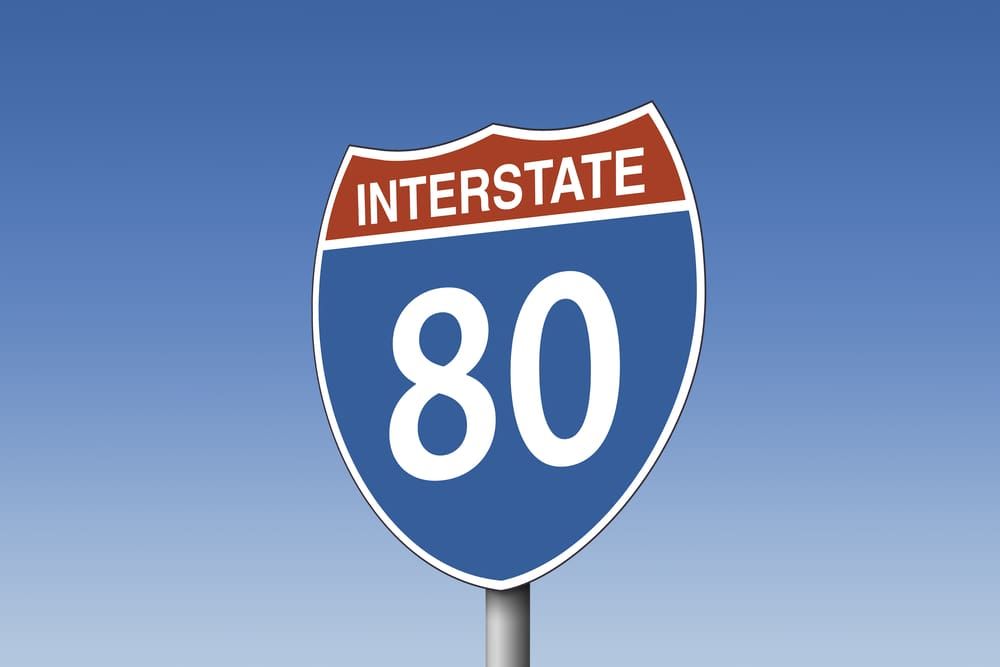 A blue interstate 80 sign against a blue sky