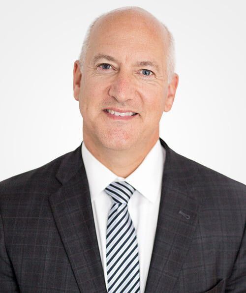 A man in a suit and tie is smiling for the camera.