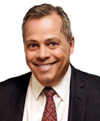 A man in a suit and tie is smiling for the camera