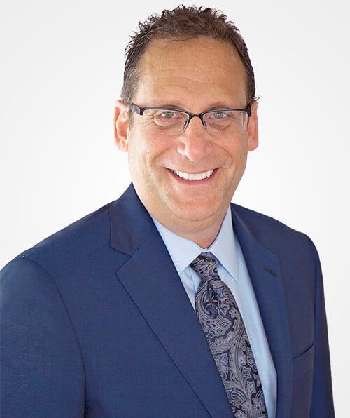 A man in a suit and tie is smiling for the camera.