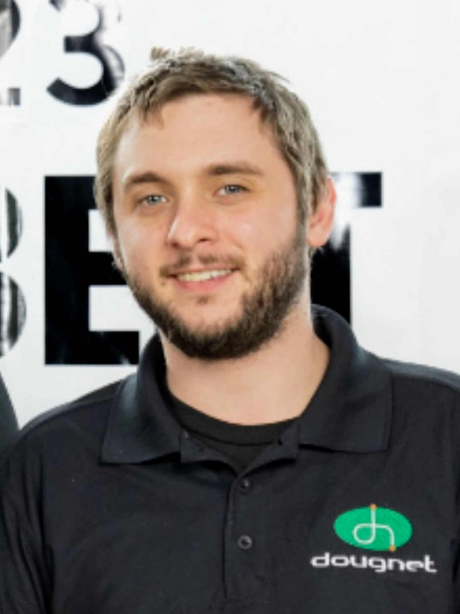 Man with light hair and beard smiles, wearing a black shirt with a dougnet logo.