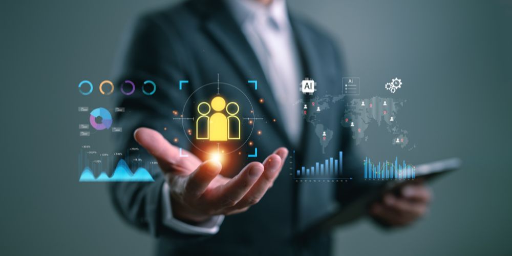 A person in a suit holding a glowing holographic display of charts, a world map, and a group of people icon.