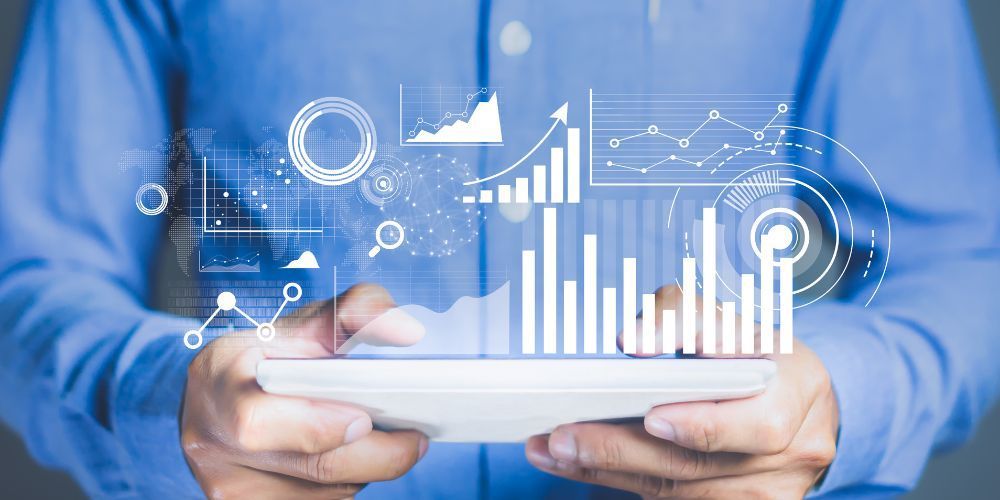Person holding a tablet displaying charts and data visualization, likely analyzing information.