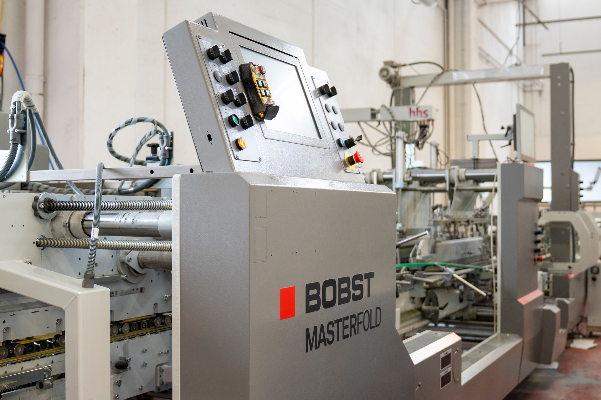 Macchina confezionatrice industriale con logo BOOST MASTER in un contesto di fabbrica.