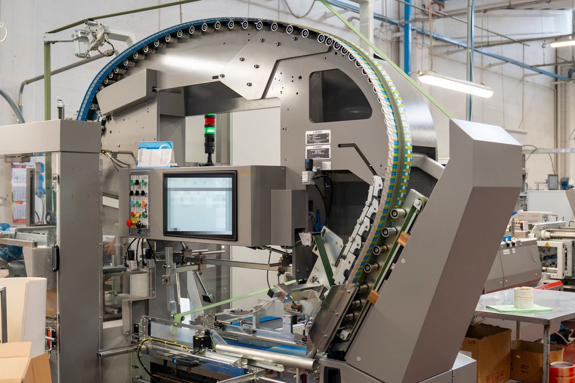 Macchinari robotici industriali in una fabbrica, con braccio di assemblaggio circolare e display monitor