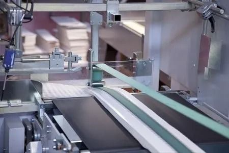 Sistema di trasporto automatizzato in fabbrica per movimentare articoli imballati lungo una linea di produzione.