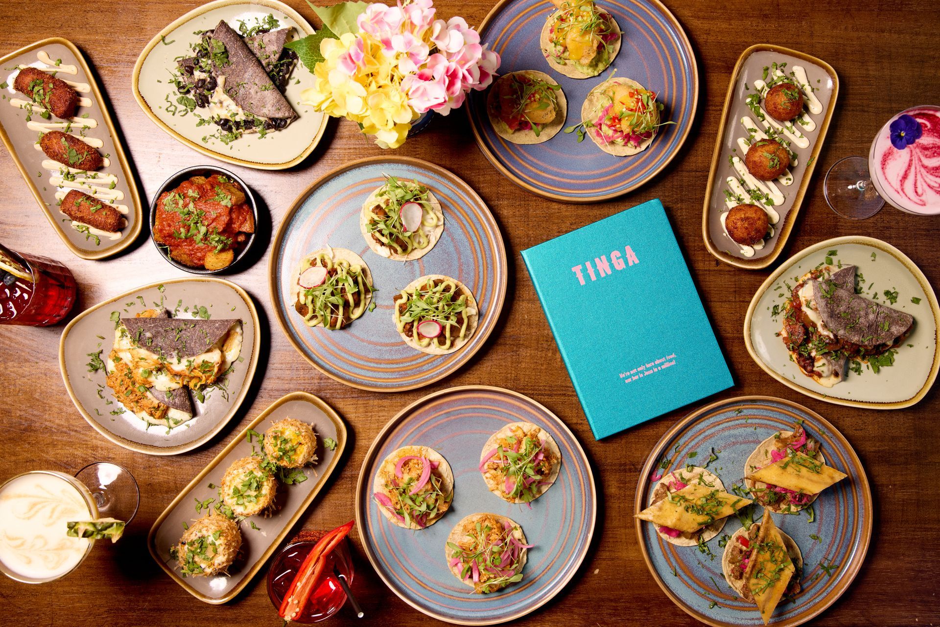 A bartender is pouring a drink from a shaker into a glass.