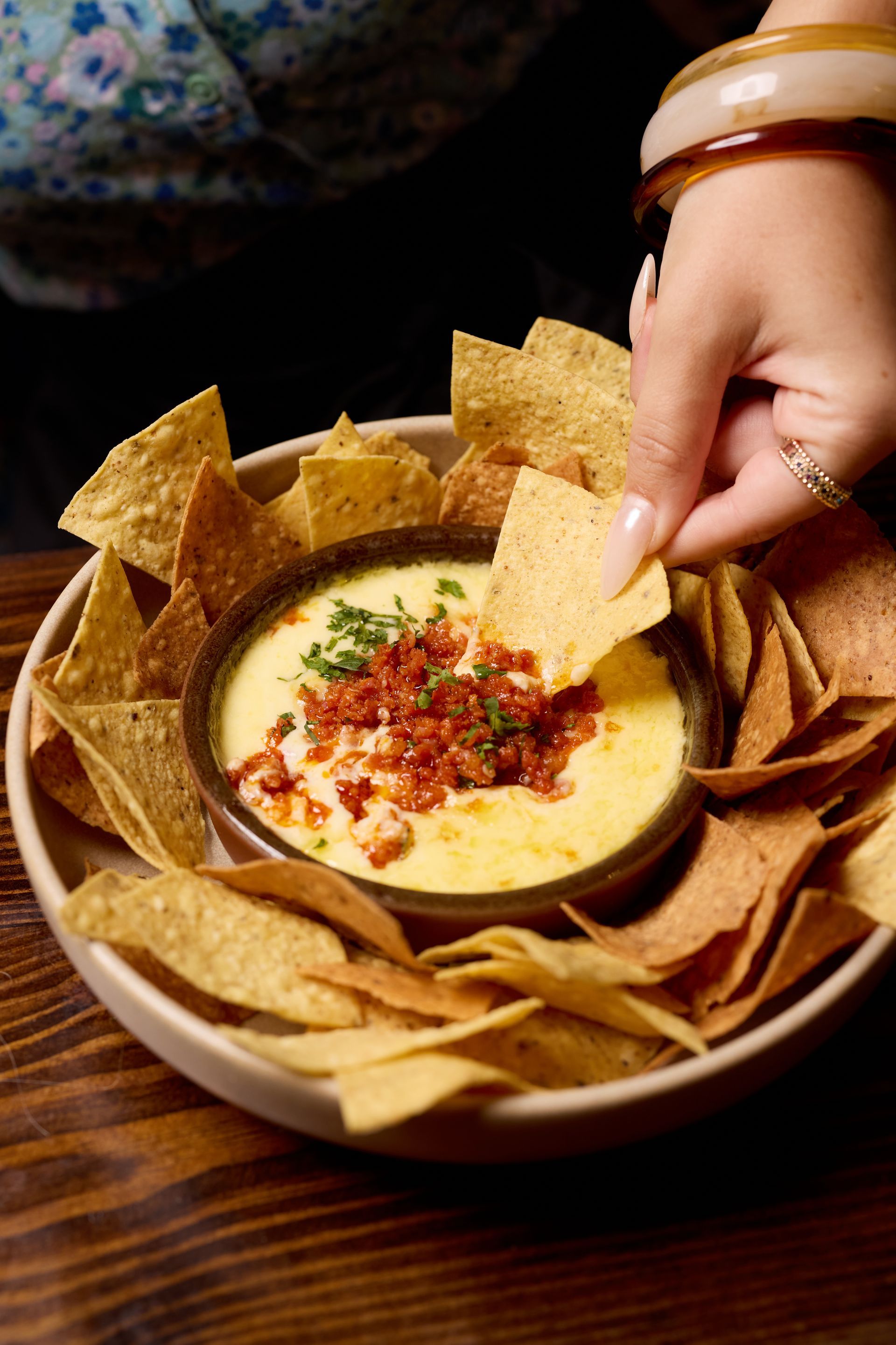 A person is squeezing lime juice on a taco on a cutting board.