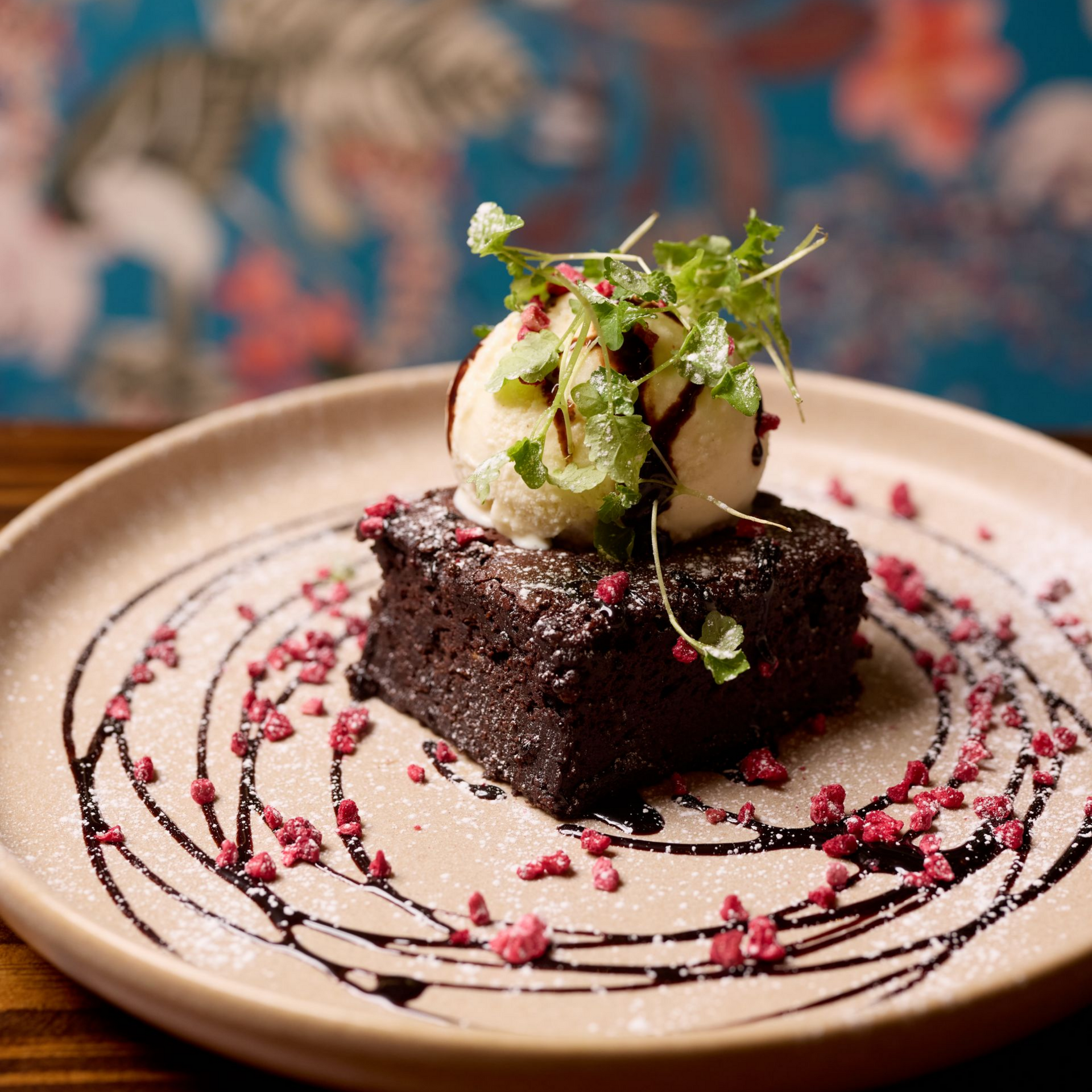 Two cocktails are sitting on a wooden table next to a skull cup.