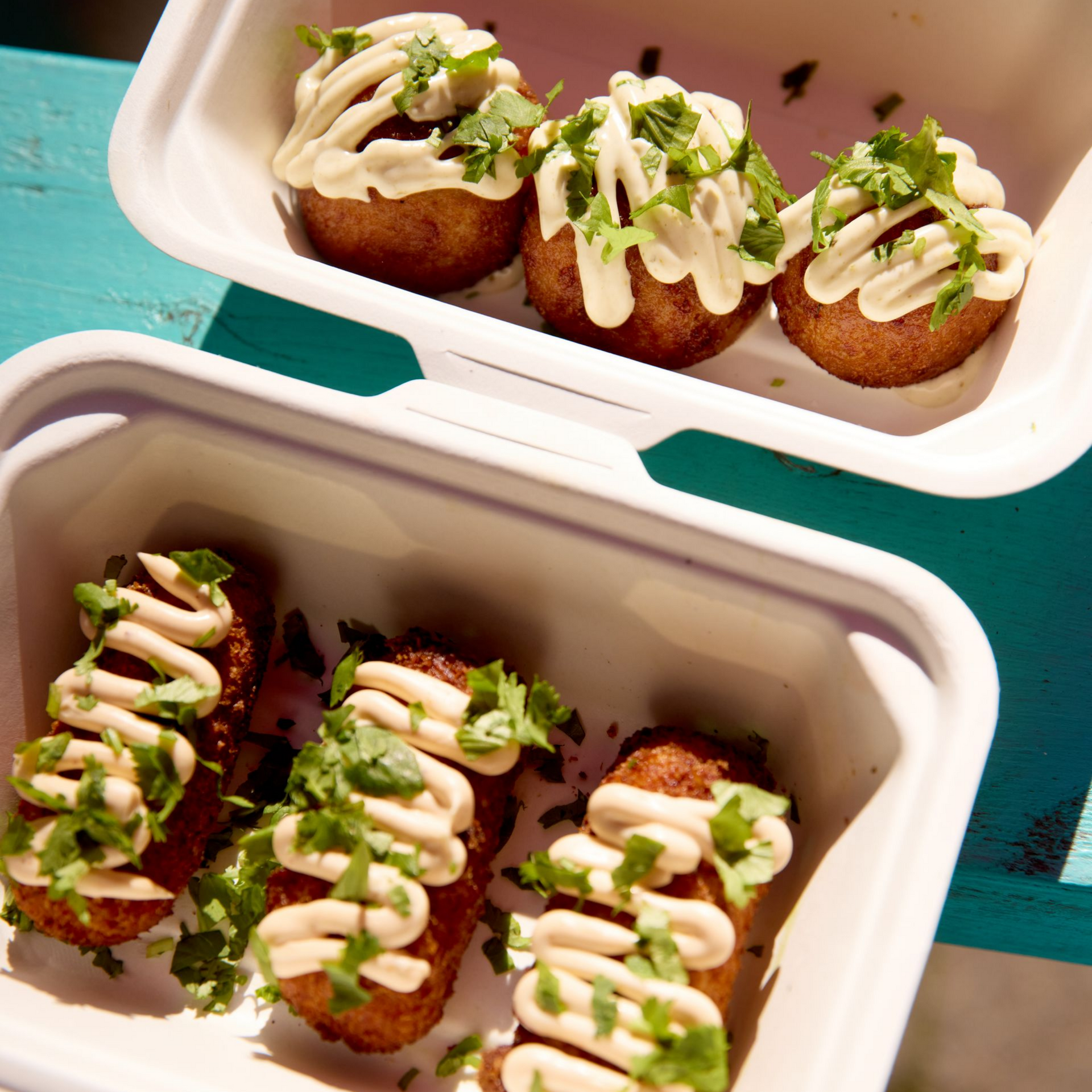 A person is holding two drinks with flowers on top of them.