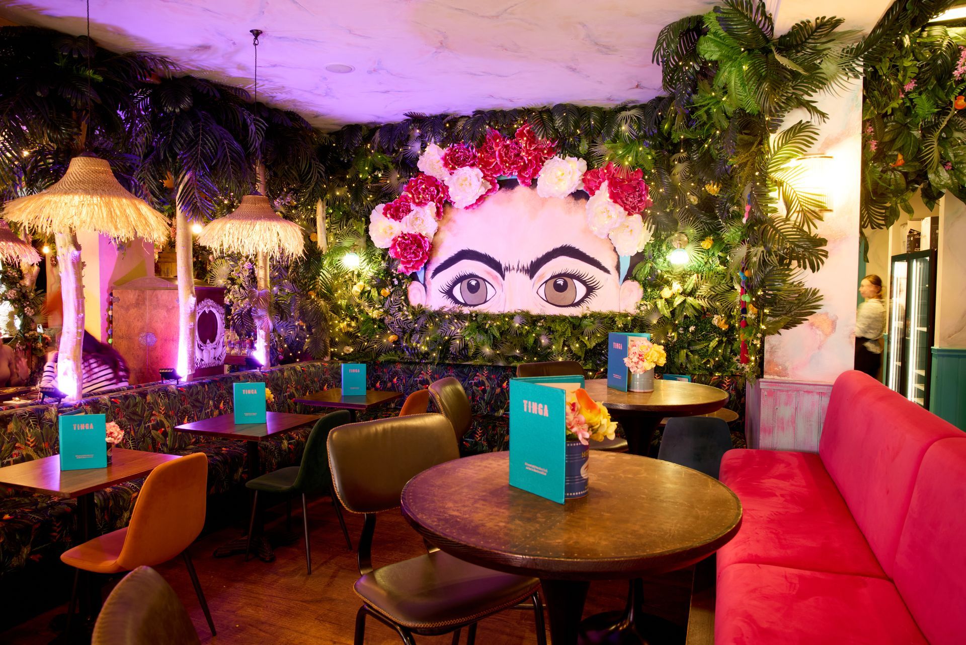 A bowl of nachos with cheese and tomatoes on a table.