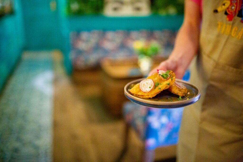 A person is holding a plate of food in a restaurant.