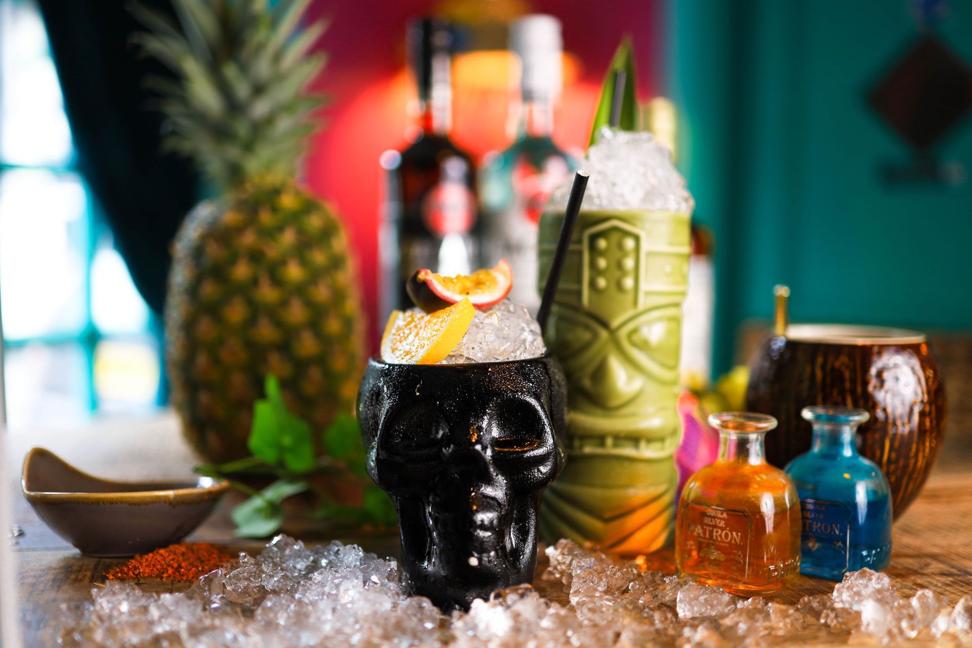 A tiki mug with a drink in it is sitting on ice on a table.