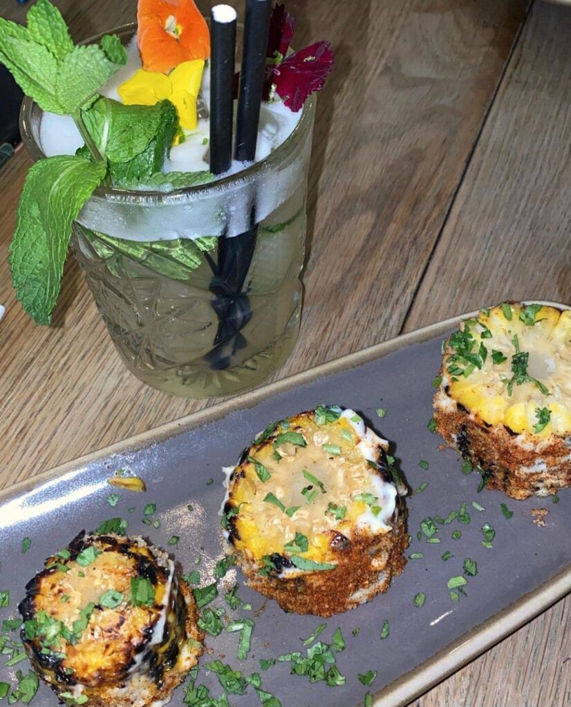 A plate of food and a drink on a table.