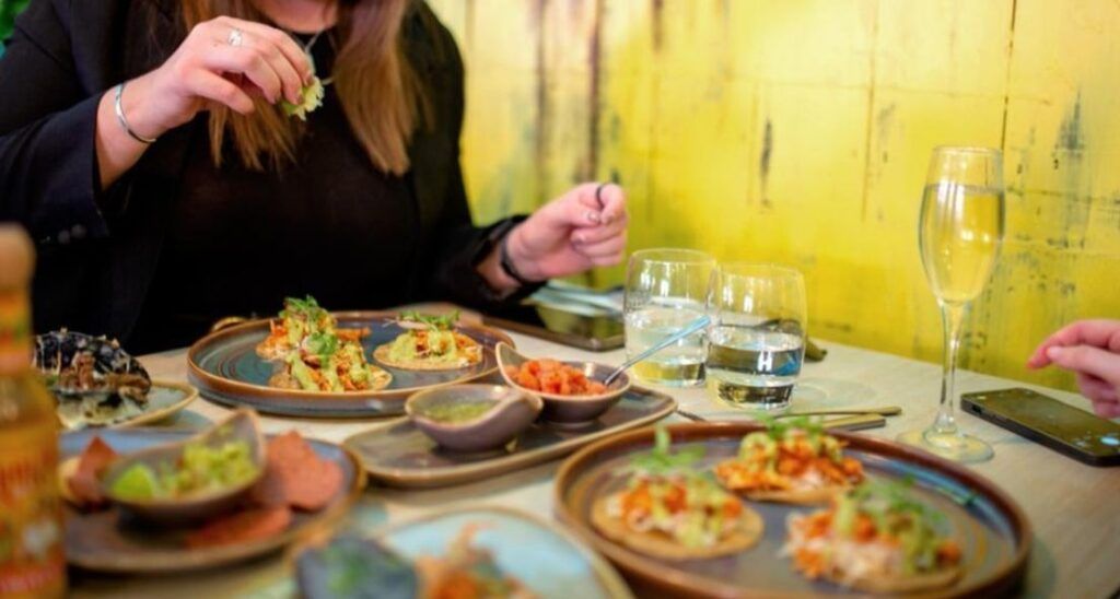 A woman is sitting at a table eating food.