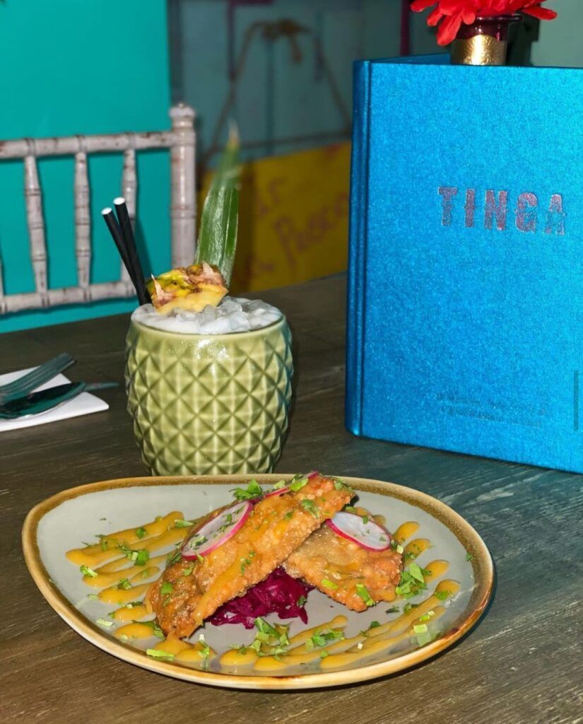 A plate of food is sitting on a table next to a blue book.