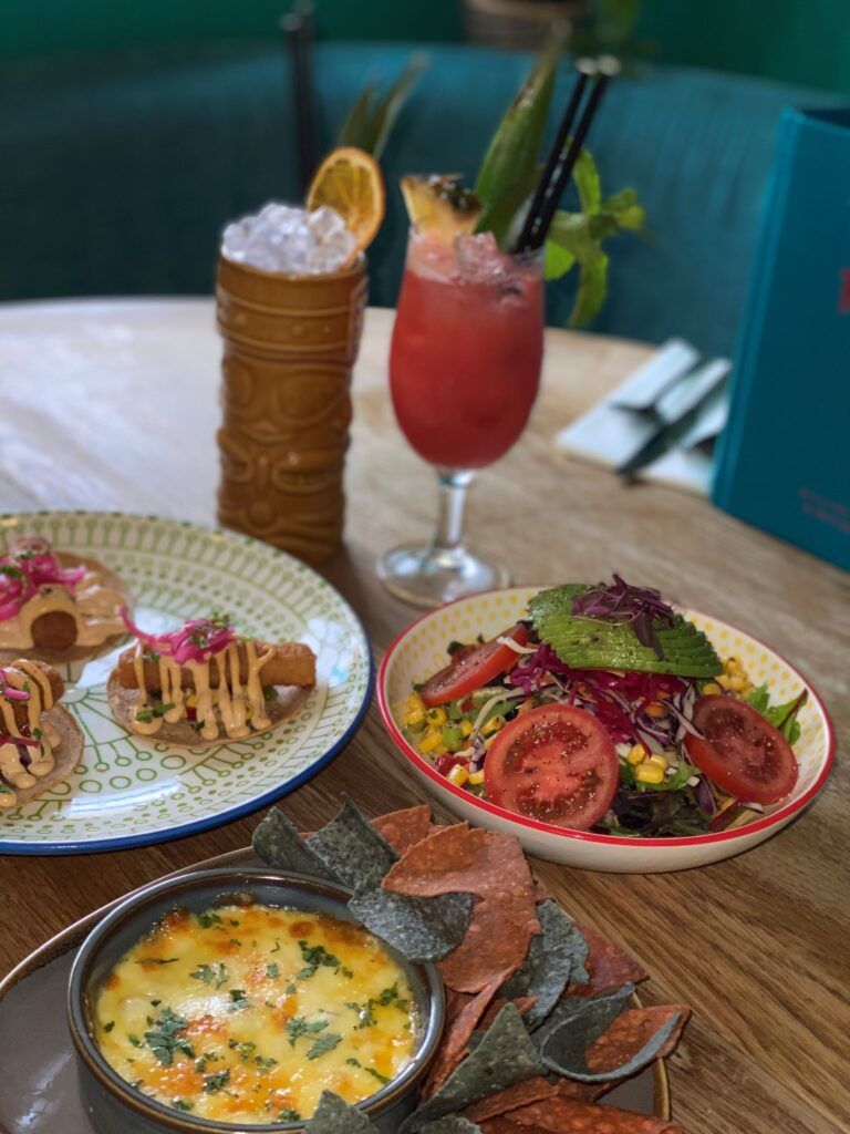 A table topped with plates of food and a drink.