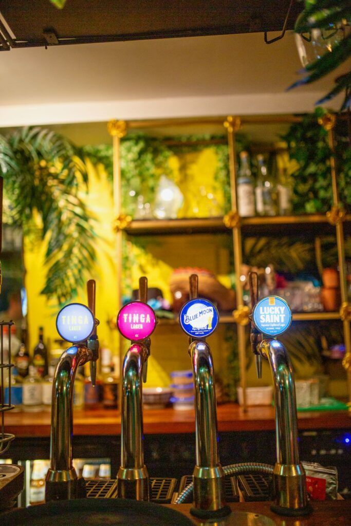 A bar with a bunch of beer taps on it.