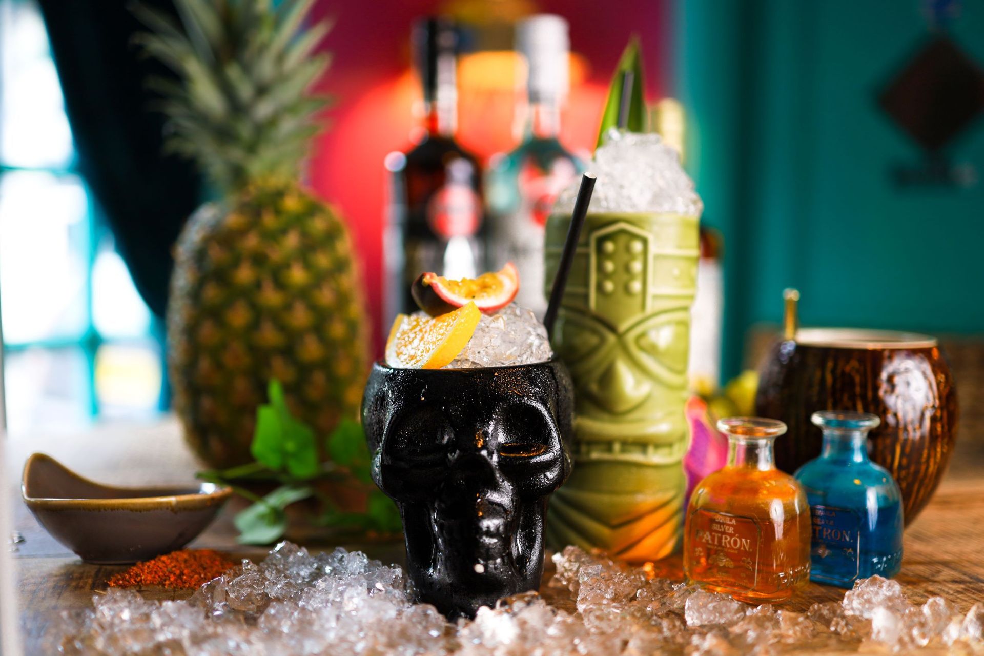 A skull shaped cup filled with ice and a drink on a table.