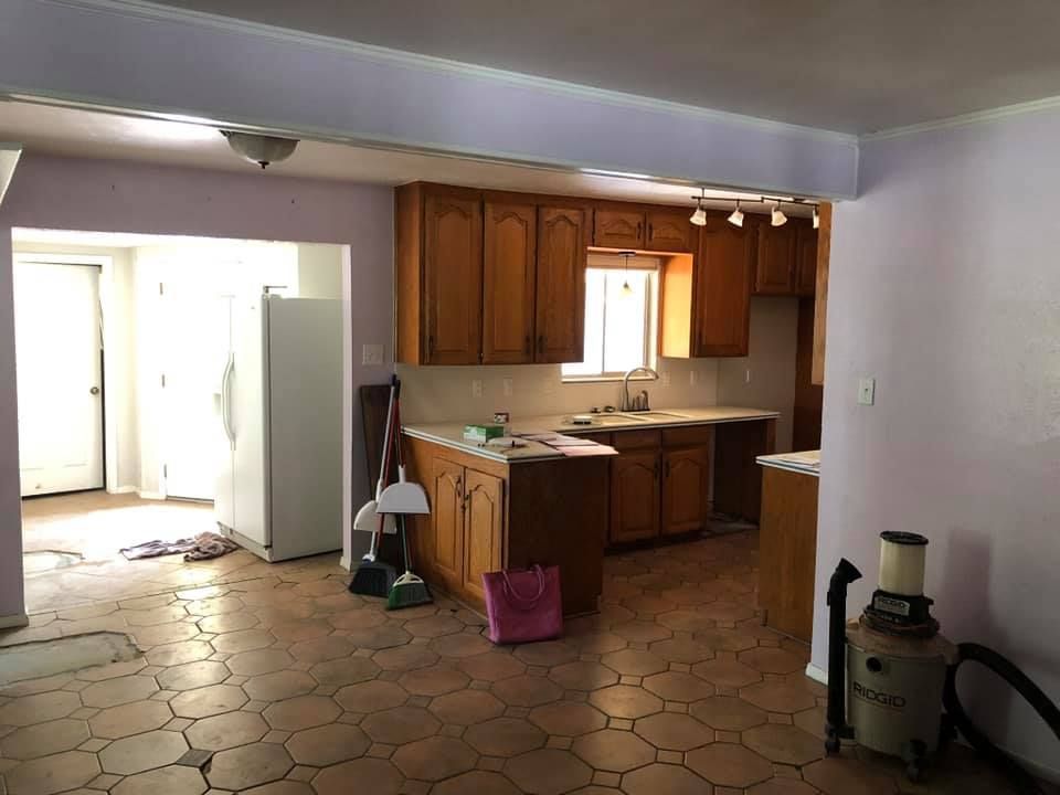 A kitchen with wooden cabinets and a tiled floor