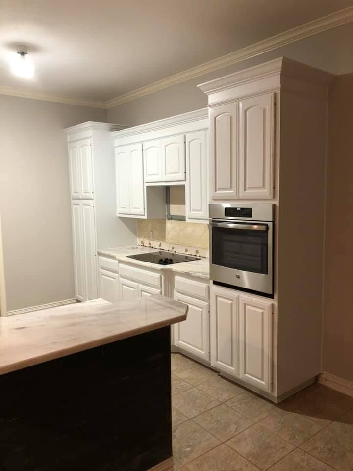 A kitchen with white cabinets and stainless steel appliances.