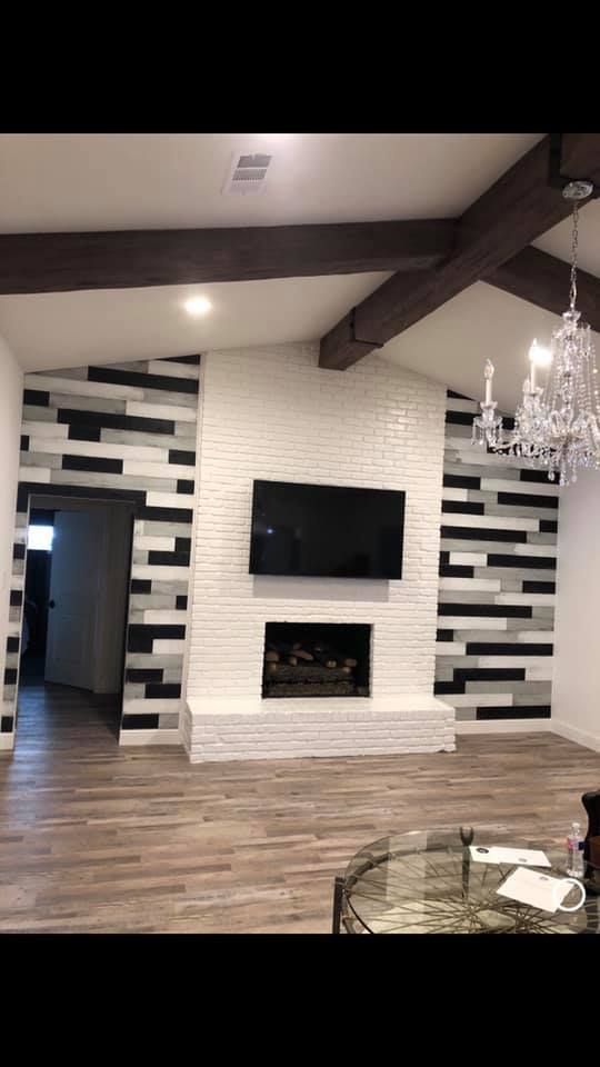 A living room with a fireplace and a flat screen tv on the wall.