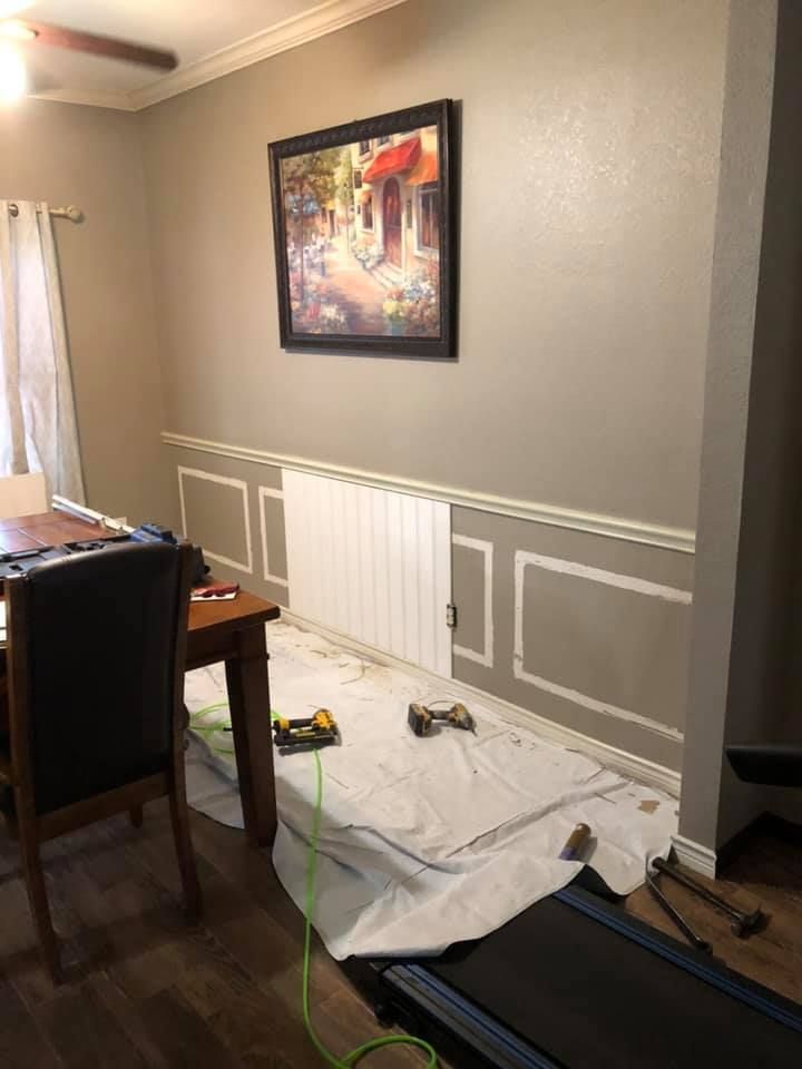 A dining room with a table and chairs and a treadmill.
