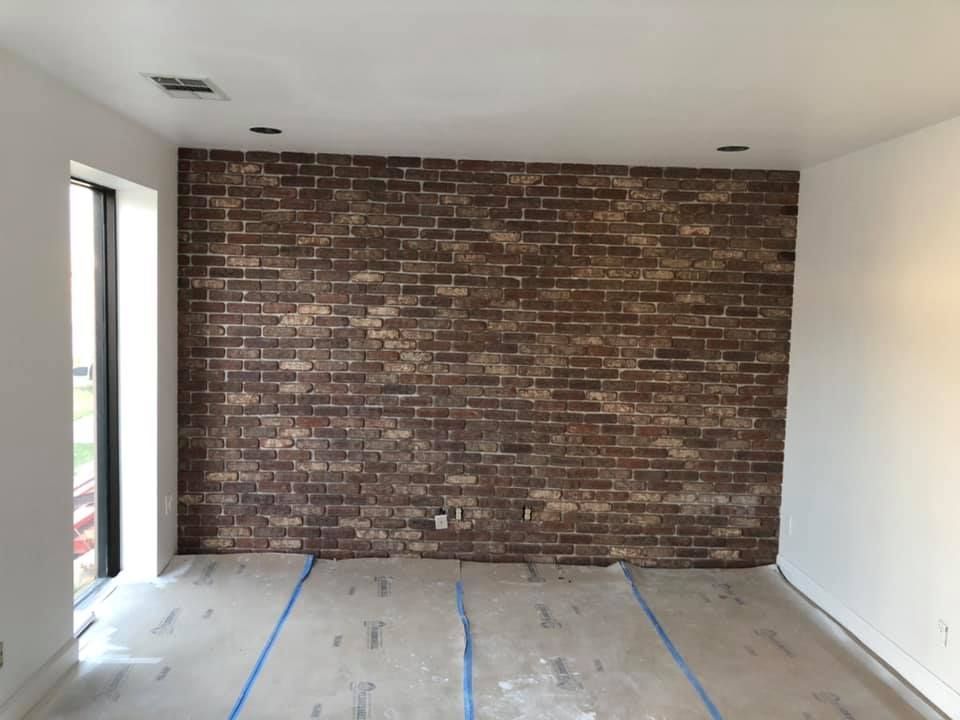 An empty room with a brick wall and a window
