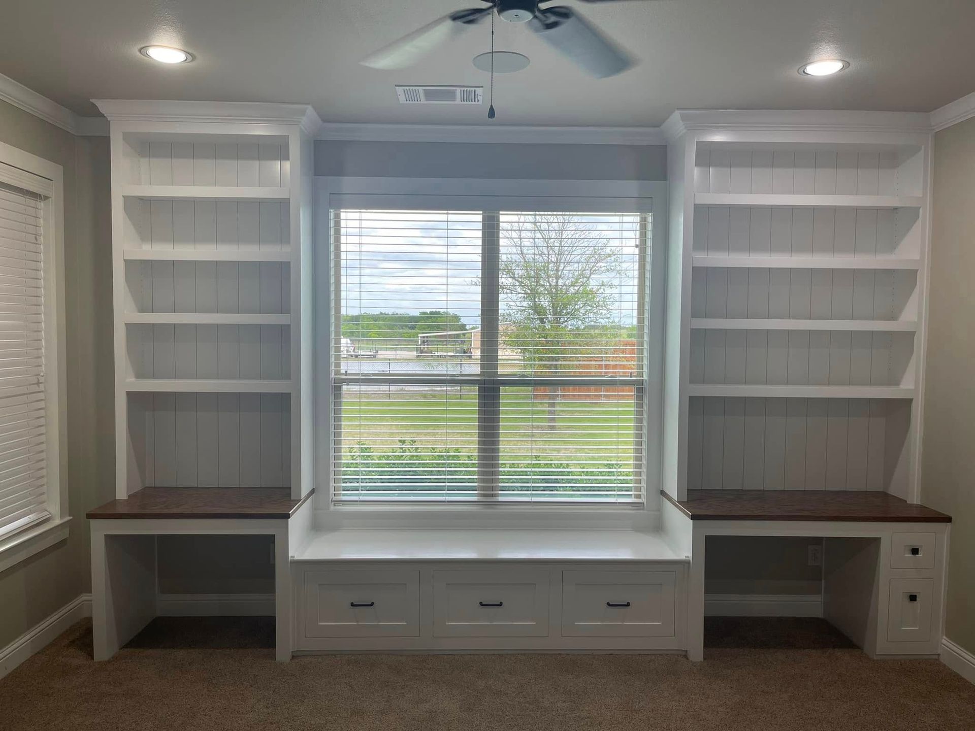 A room with shelves and a window with blinds