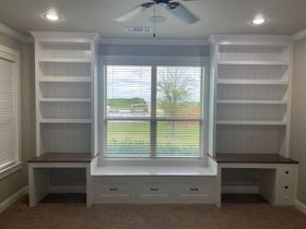 A room with shelves and a window with blinds