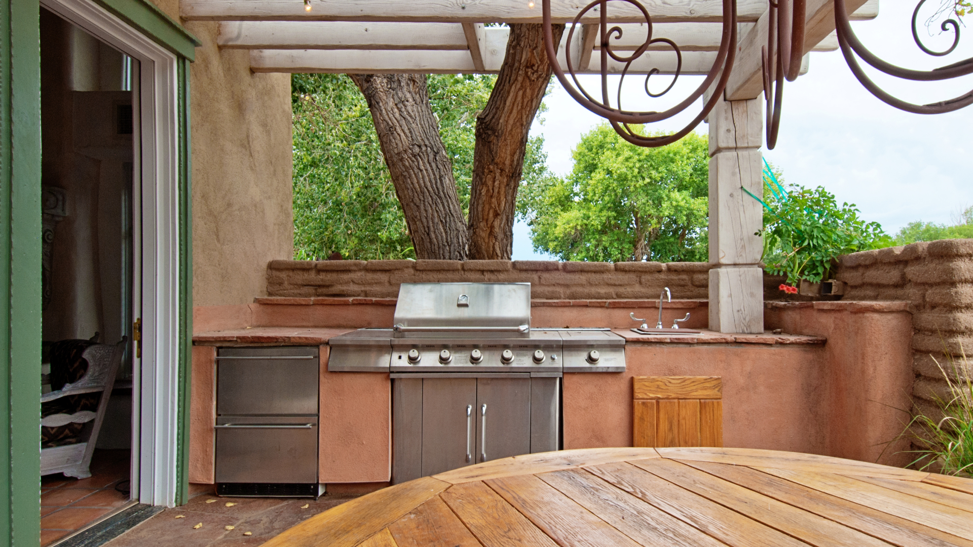 A patio with a grill and a wooden table