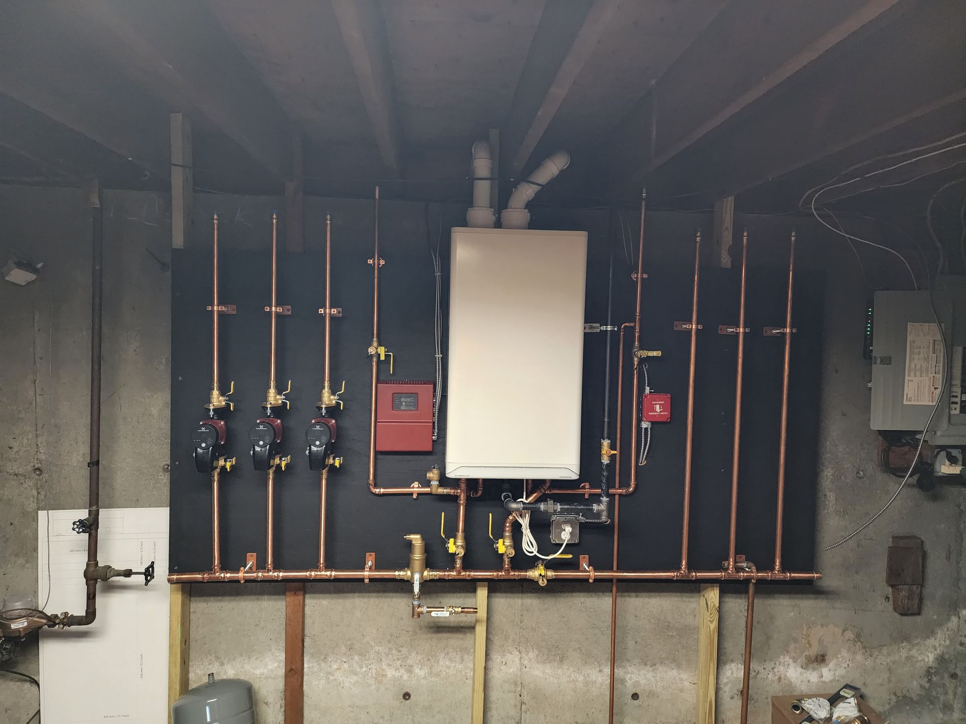 A boiler is hanging on a wall with copper pipes.