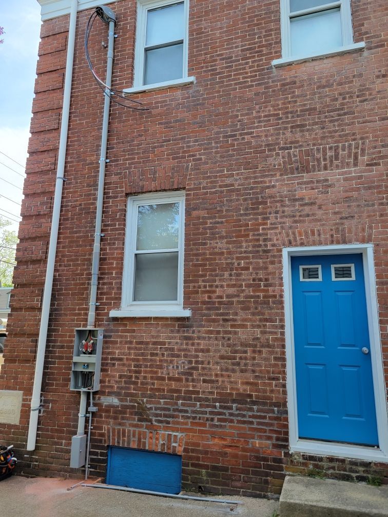 A brick building with a blue door and window