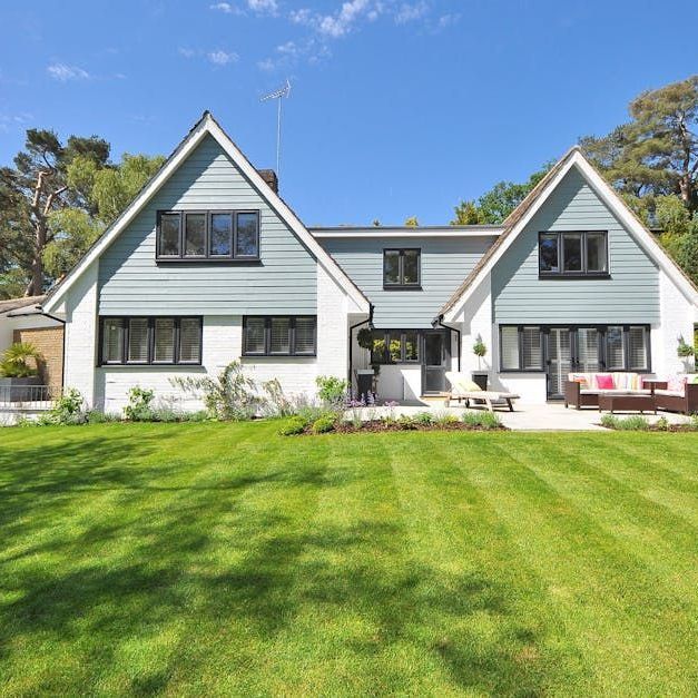 A large house with a lush green lawn in front of it.