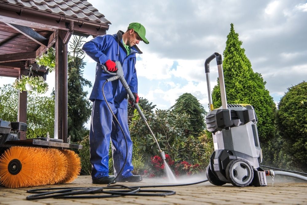 Professional Pressure Washing in Austin, TX. Caucasian Men Washing Residential Bricks Made Driveway.