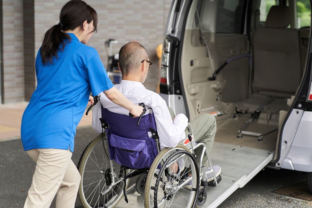 Woman assisting a Disabled Male Senior to the Van