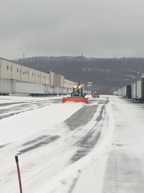 Salt truck spraying road with salt on a snowy highway.