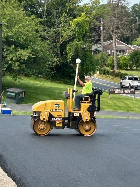 Newly paved black asphalt driveway in a residential neighborhood.