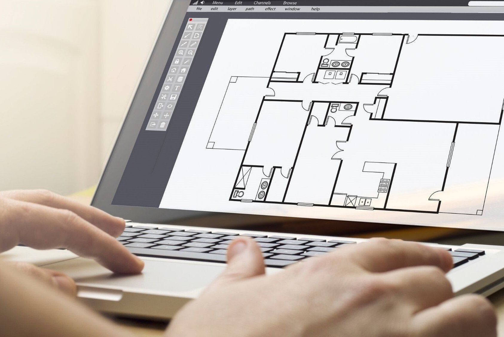 floor plan on laptop screen with persons hands working on computer