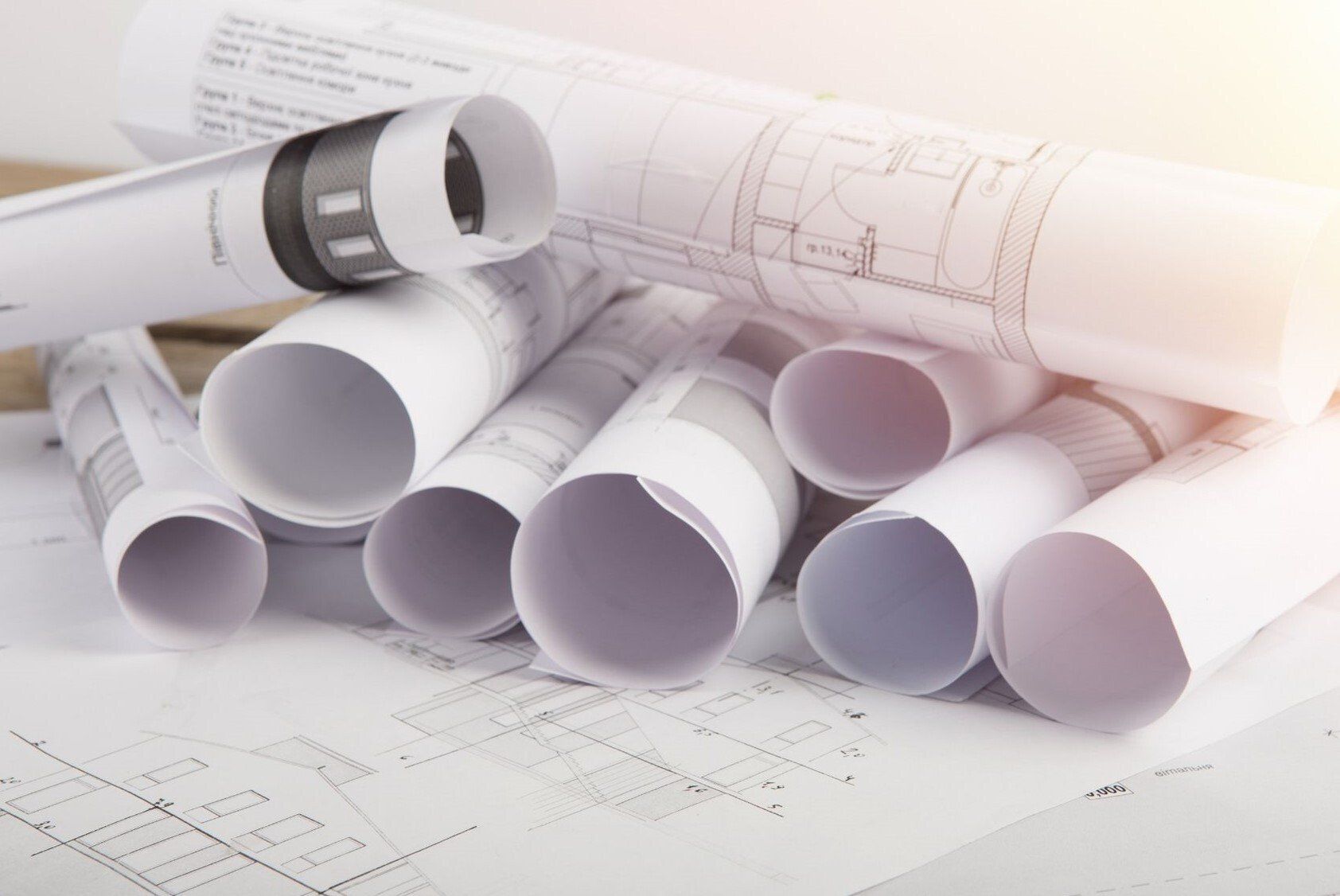 rolls of architectural drawings stacked up on table