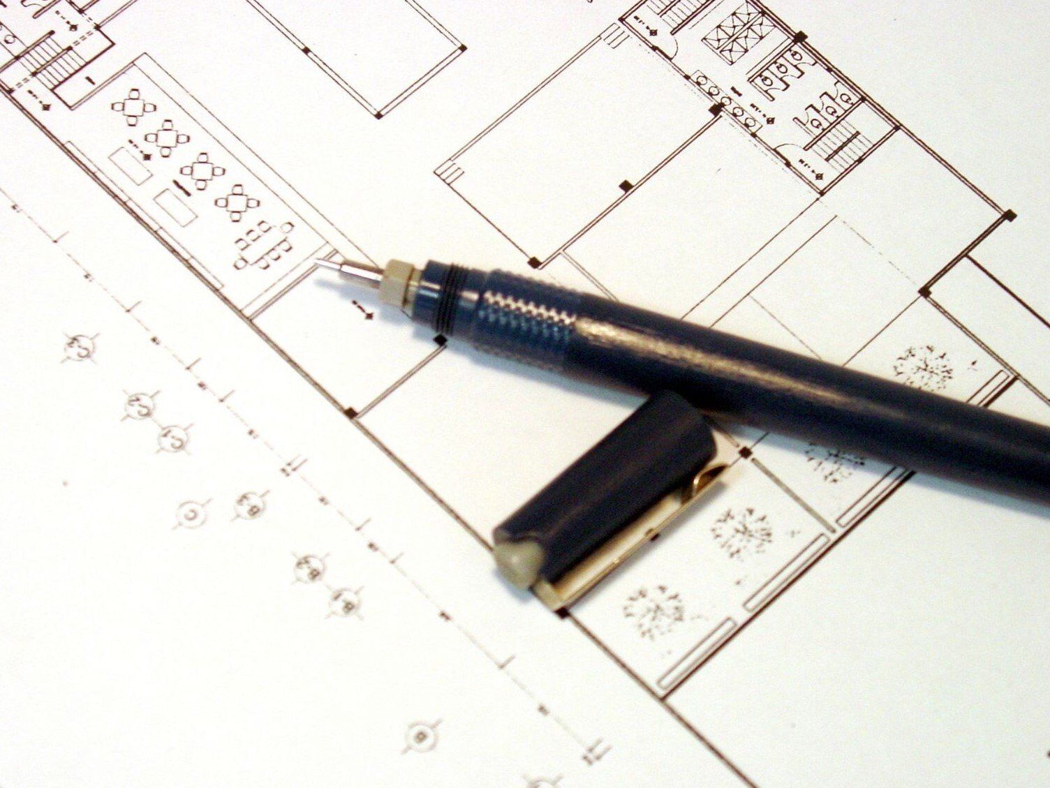 drawing of commercial floor plan with black pen and lid on top