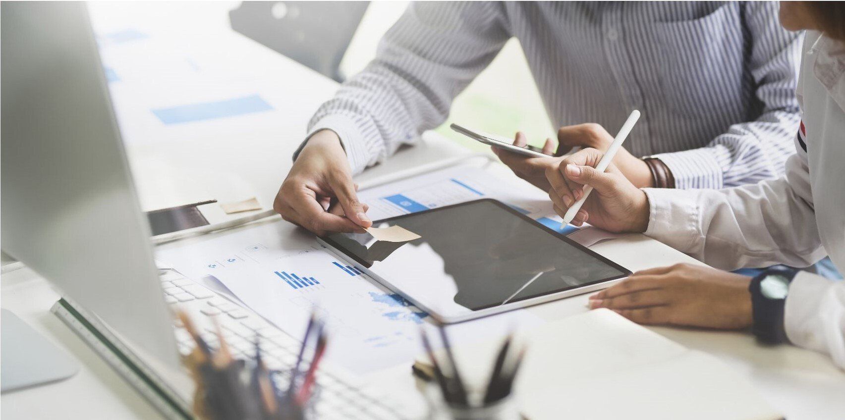 people working around an i-pad at a desk