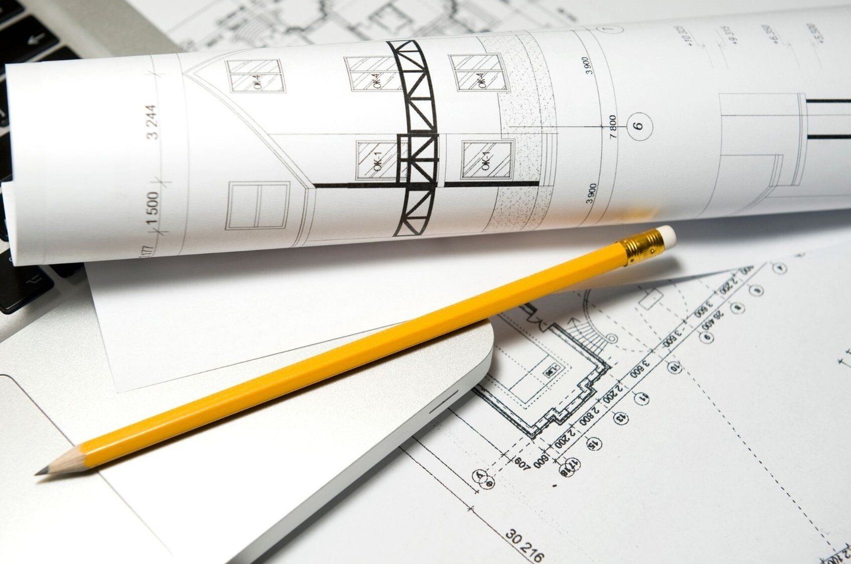 architectural drawings stacked up with yellow pencil on top