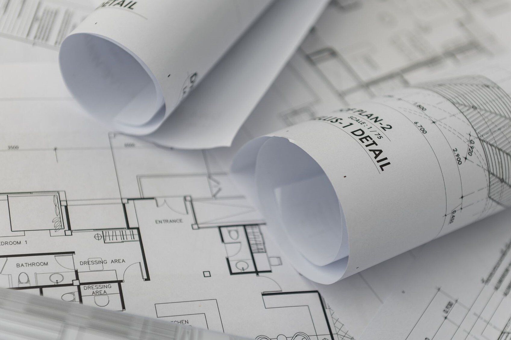 two drawing rolls on top of another architectural drawing floor plan