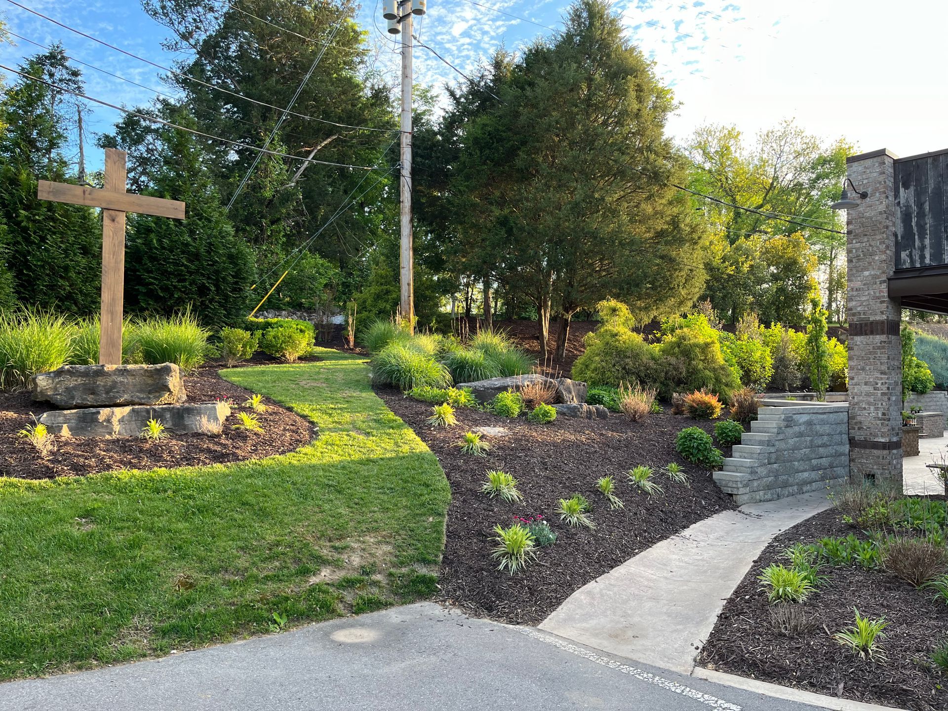 A large wooden cross is in the middle of a lush green field.