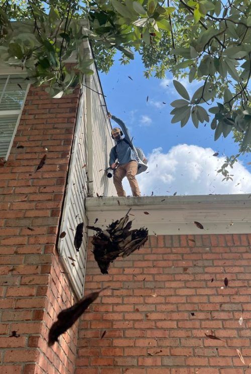 A man is standing on the roof of a brick building.
