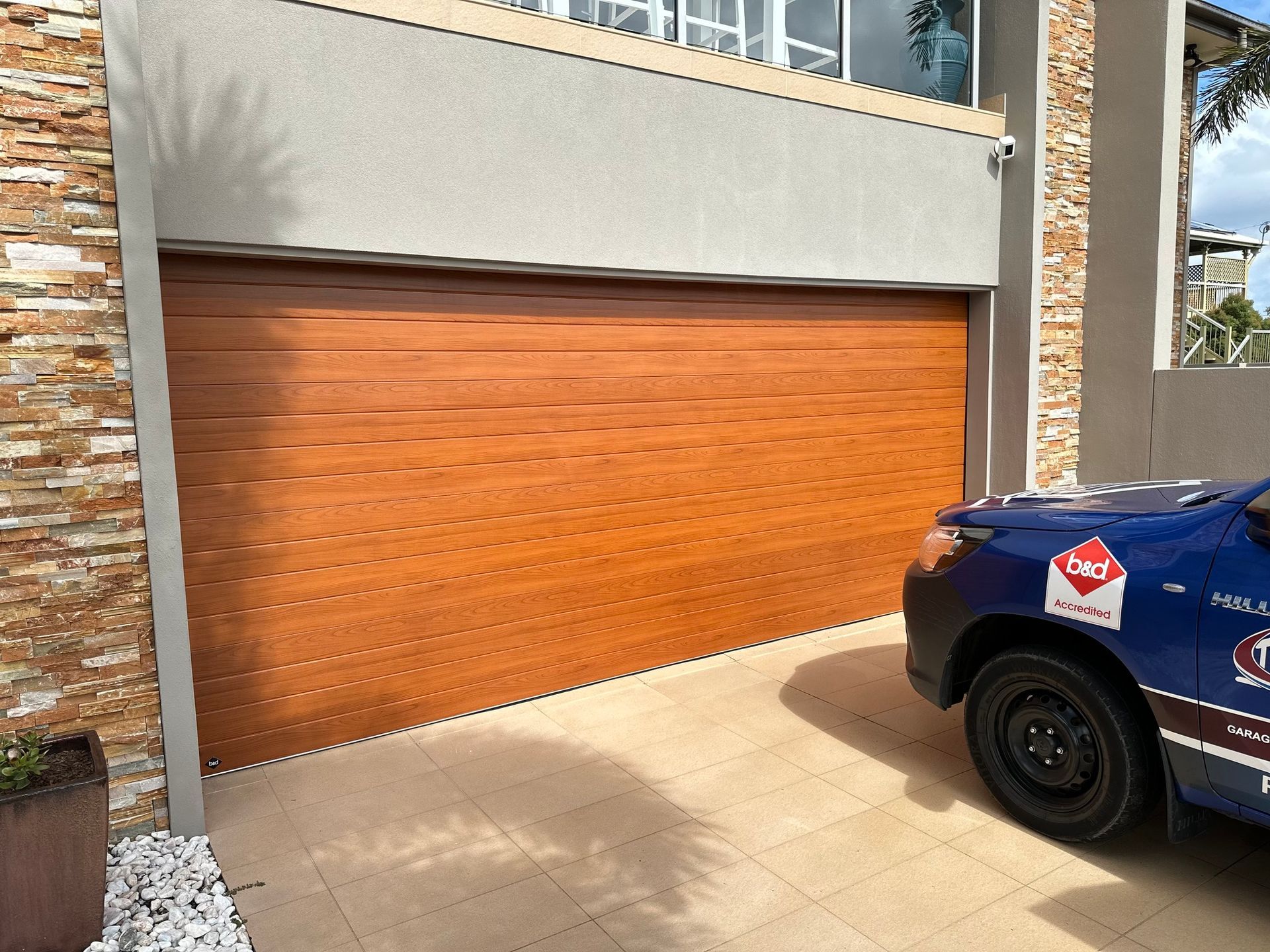 Wooden garage door, tan walls, and a blue car parked in front.
