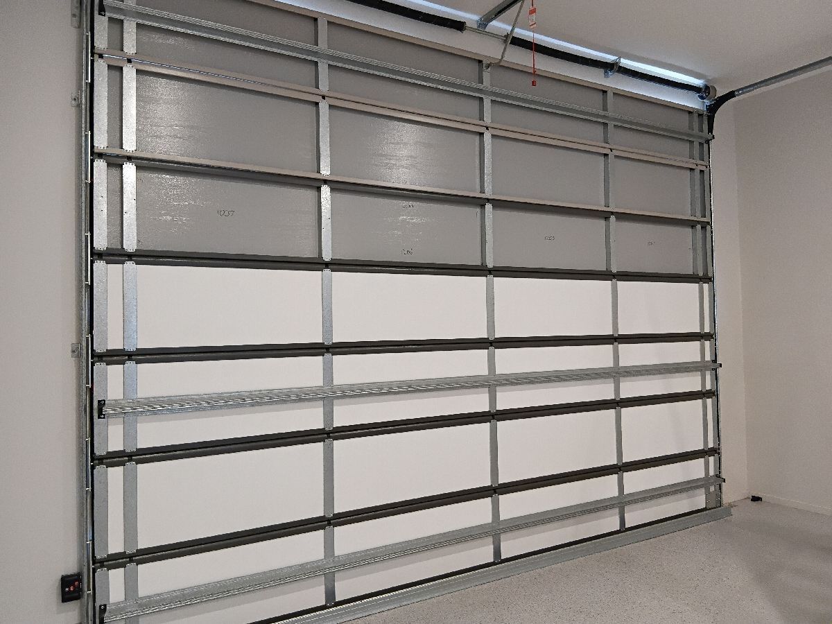 Open garage door with a metal frame and horizontal white panels.